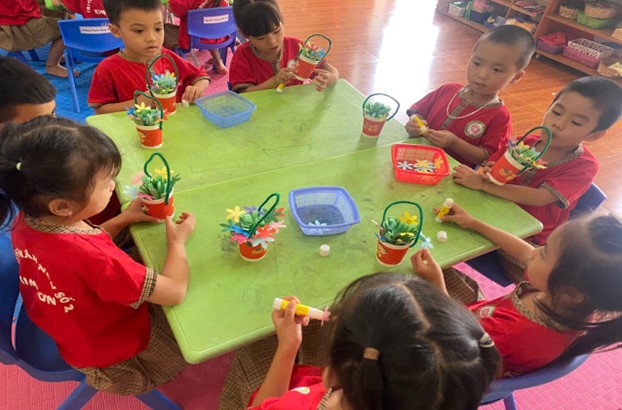 Ảnh: các con đang làm các giỏ hoa tặng bà, tặng mẹ, tặng cô và các bạn gái.